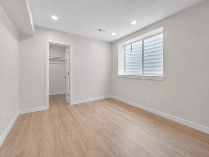 Basement bedroom with walk-in closet and wide egress window