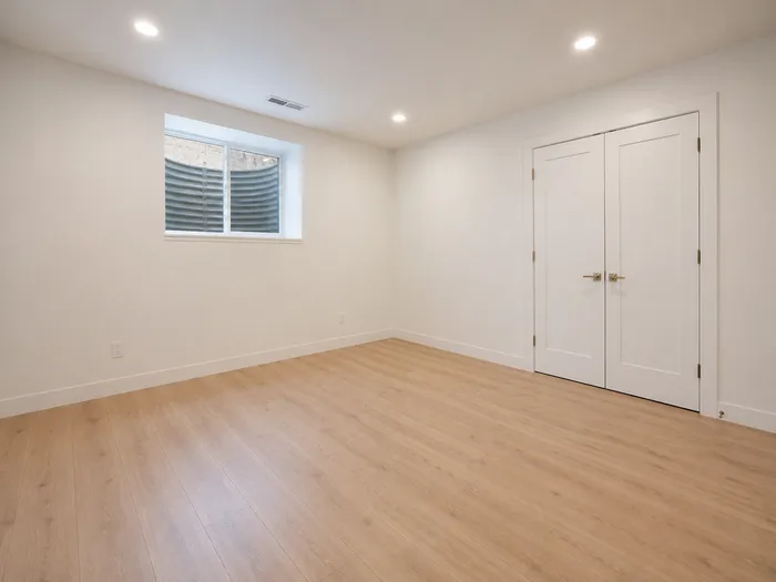 Basement bedroom with egress window and double-door closet