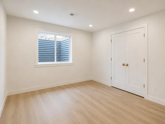 Basement bedroom with window well window and double closet doors
