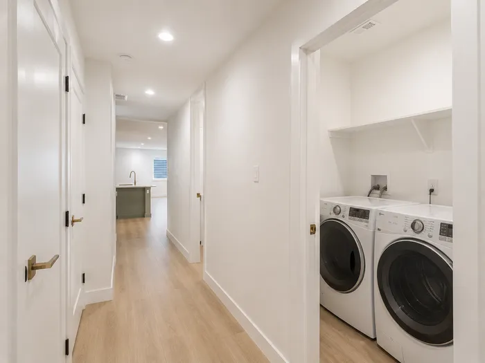 Basement hallway leading to the kitchenette, with laundry closet